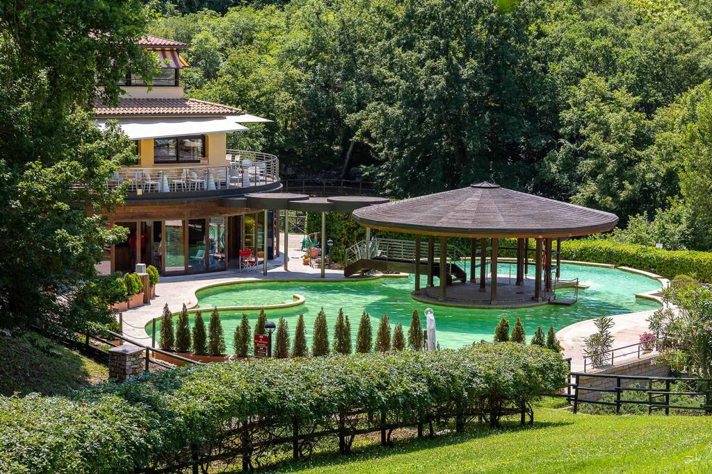Piscina termale con gazebo immersa nel verde in Maremma